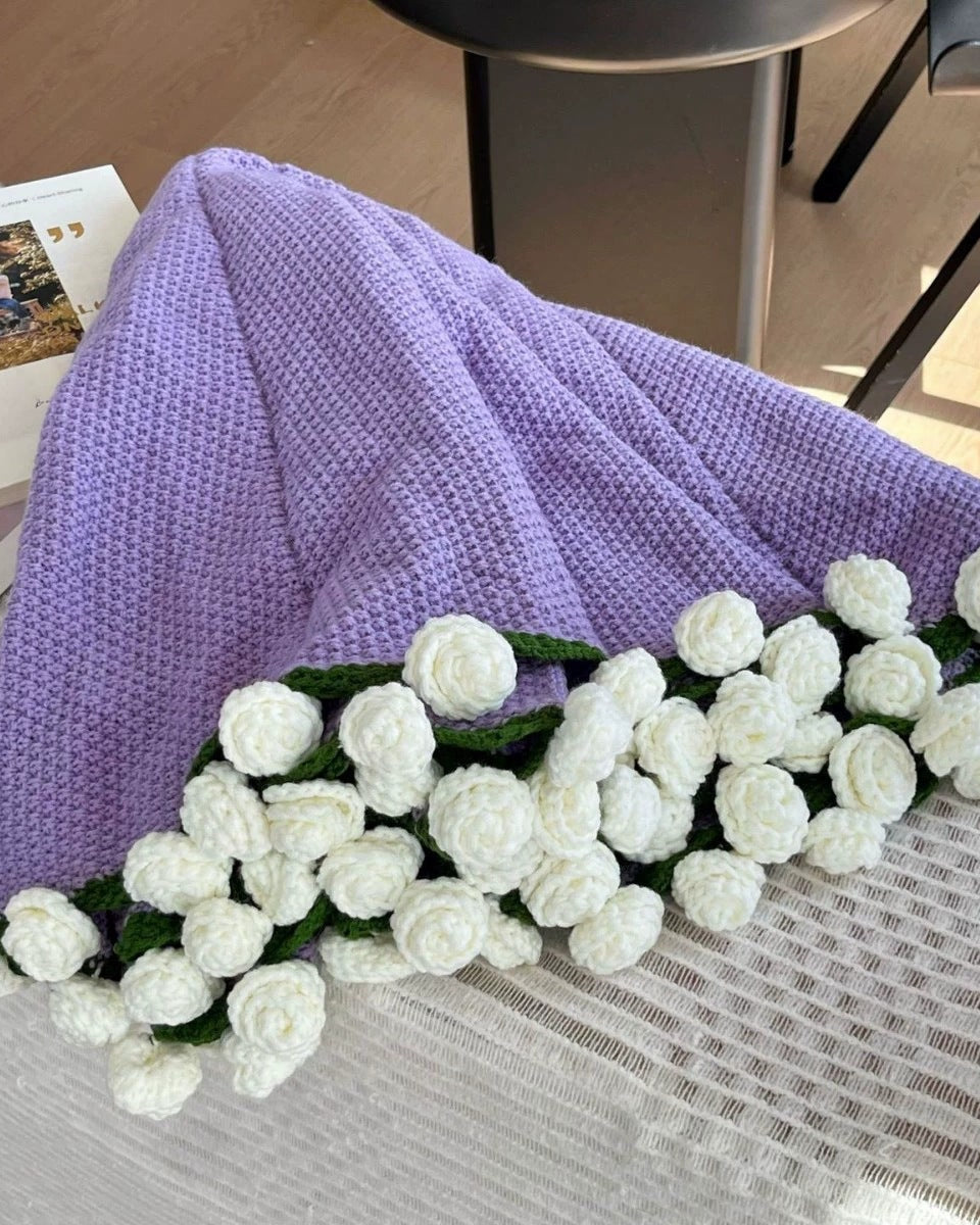 White roses on a lavender blanket, partly unfolded (supplier photo, cropped)